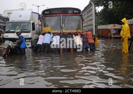 Mumbai, Inde. 23 septembre 2020. Les gens poussent un bus de transport en commun sur une route en eau. De fortes pluies ont heurté la ville, ce qui a entraîné l'engorgement et les gens ont de la difficulté à traverser les eaux inondées. Crédit : SOPA Images Limited/Alamy Live News Banque D'Images