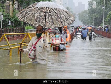 Mumbai, Inde. 23 septembre 2020. Un homme tenant un parapluie et un bâton de marche wade à travers la taille de l'eau profonde.de fortes pluies ont heurté la ville résultant en l'engorgement et les gens ayant de la difficulté à faire à travers les eaux inondées. Crédit : SOPA Images Limited/Alamy Live News Banque D'Images