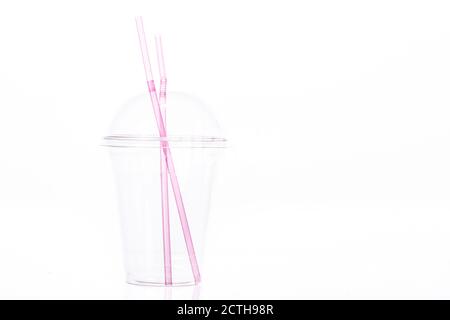 Gobelet en plastique transparent vide avec couvercle dôme et deux roses pailles en plastique pour milkshake Banque D'Images