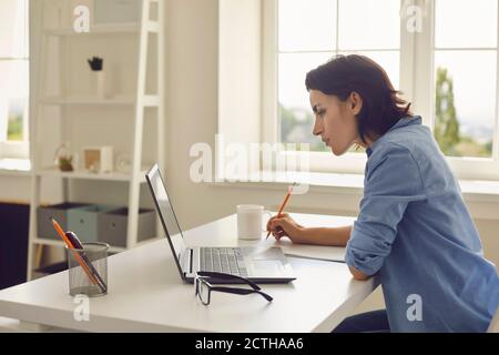 Femme écoutant quelqu'un pendant une leçon en ligne ou une conférence Banque D'Images