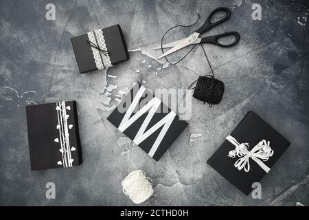 Boîte noire de Noël avec ciseaux et ficelle sur foncé. Concept de vacances. Pose à plat. Vue de dessus Banque D'Images