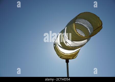 Blanc - Boudin de vent jaune sur le poteau sur le fond bleu ciel tourné avec l'espace de copie. Banque D'Images