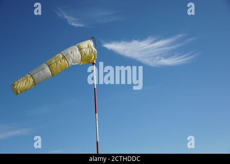 Blanc - Boudin de vent jaune sur le poteau sur le fond bleu ciel tourné avec l'espace de copie. Banque D'Images