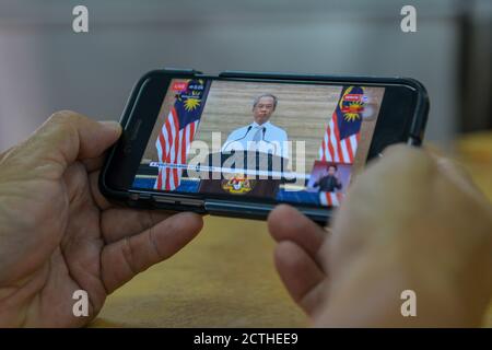 Kuala Lumpur, Malaisie. 23 septembre 2020. Un homme regarde le discours télévisé du Premier ministre malaisien Muhyiddin Yassin par téléphone portable dans un restaurant de Kuala Lumpur, en Malaisie, le 23 septembre 2020. Le Premier ministre malaisien Muhyiddin Yassin a déclaré mercredi que le chef de l'opposition Anwar Ibrahim devait prouver qu'il avait recueilli le soutien d'une majorité de députés, sinon ce ne serait qu'une allégation. Credit: Chong Voon Chung/Xinhua/Alay Live News Banque D'Images