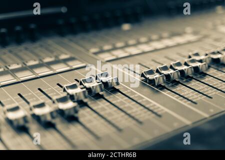 Console de mixage audio professionnelle avec faders et boutons de réglage, équipement de télévision mise au point sélective noir et blanc Banque D'Images