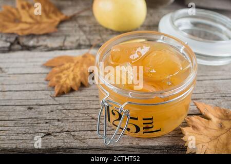 Confiture de pommes ou sauce maison dans un pot sur la table. Arrière-plan rustique en bois. Banque D'Images