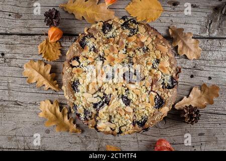 Cuisine d'automne confortable. Gâteau d'automne maison avec noix et prunes sur fond de bois, vue de dessus, espace copie. Banque D'Images