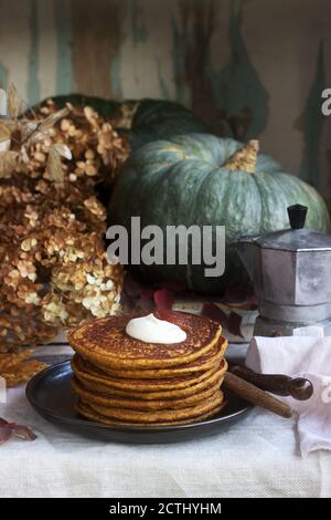 Crêpes à la citrouille avec crème et de la confiture sur un fond d'automne de la vie encore. Banque D'Images