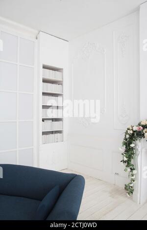 Canapé par mur à la maison, intérieur scandinave du concept de salon, canapé gris clair avec lampe or sur sol blanc Banque D'Images