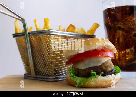 Cheeseburger avec frites et Coca-Cola sur bois, on Arrière-plan blanc Banque D'Images