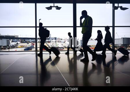 Silhouettes de voyageurs aériens se déplacent entre les terminaux pour prendre des vols pendant une pandémie à l'aéroport O'Hare de Chicago Banque D'Images