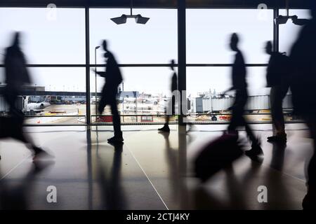 Silhouettes de voyageurs aériens se déplacent entre les terminaux pour prendre des vols pendant une pandémie à l'aéroport O'Hare de Chicago Banque D'Images