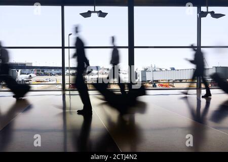 Silhouettes de voyageurs aériens se déplacent entre les terminaux pour prendre des vols pendant une pandémie à l'aéroport O'Hare de Chicago Banque D'Images