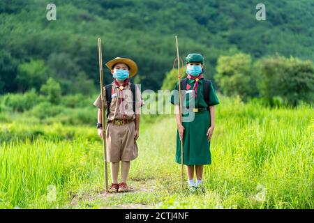 Scout asiatique portant un masque et debout droit, nouvelle norme Banque D'Images