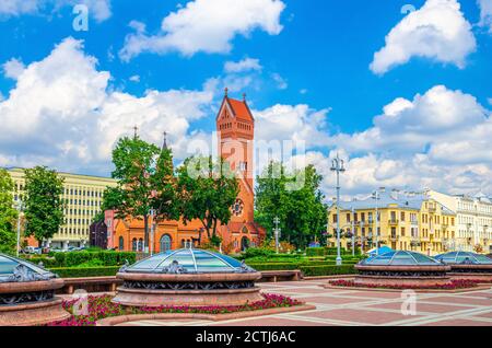 Église catholique romaine Saints Simon et Helena ou Église rouge sur la place de l'indépendance dans le centre historique de la ville de Minsk, ciel bleu nuages blancs dans la journée ensoleillée d'été, République du Bélarus Banque D'Images