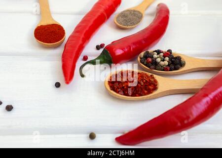 Piment rouge chaud et mélange de poivre sur un fond en bois blanc Banque D'Images