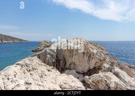 De belles falaises rocheuses sur la rive de l'île de Hvar, créant un abri pour le port voisin et les bateaux ancrés des vagues et des vents forts Banque D'Images