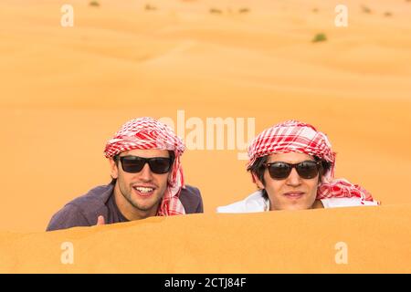 Deux heureux touristes masculins appréciant un safari dans les dunes de sable du désert arabe. Voyages et tourisme. Banque D'Images