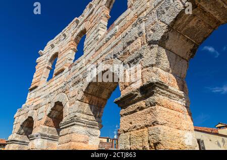 Murs en pierre calcaire avec arches fenêtres de l'Arena de Vérone dans le centre historique de la ville de Vérone, amphithéâtre romain Arena di Verona ancien bâtiment, vue de dessous, ciel bleu, région de Vénétie, nord de l'Italie