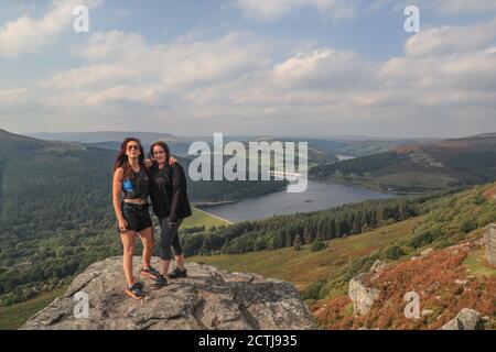 Deux marcheurs se tiennent sur le bord de Bamford Edge surplombant le réservoir Ladydower lors d'un jour d'incertitude alors que le gouvernement envisage de remettre le Royaume-Uni en état de verrouillage en raison d'une pointe dans les cas Covid 19. Banque D'Images