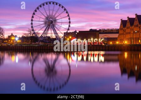 Rivière Motlawa et grande roue avec réflexion d'eau dans la vieille ville de Gdansk la nuit, Pologne Banque D'Images