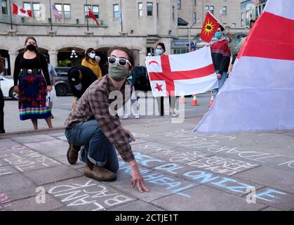Ottawa, Canada. 23rd septembre 2020. Les membres des groupes locaux des Premières nations écrivent un message de craie sur le trottoir pendant qu'ils se réunissent pour chanter des chansons cérémonielles et ont de l'espace pour mettre en avant diverses injustices des autorités canadiennes, Banque D'Images