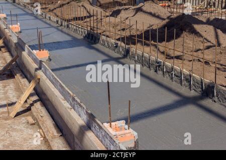 Concrétisant la base du bâtiment. Le béton de l'ouvrier de construction coule pendant le béton commercial des planchers de bâtiment dans le chantier de construction Banque D'Images