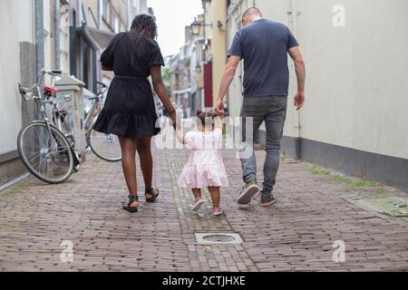 Un jeune couple marchant avec leur fille Banque D'Images