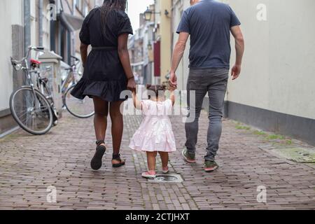 Un jeune couple qui marche sa fille dans les rues européennes Banque D'Images