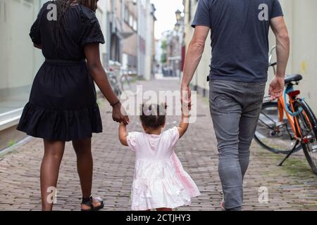 Une famille interraciale marchant dans une ville hollandaise Banque D'Images