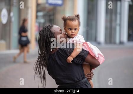 Une mère noire câlin sa fille dans la ville Banque D'Images