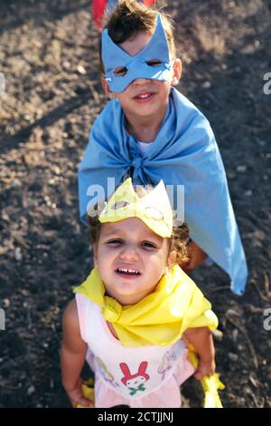 les enfants déguisés en super héros pour jouer sur le terrain, regardent o Banque D'Images