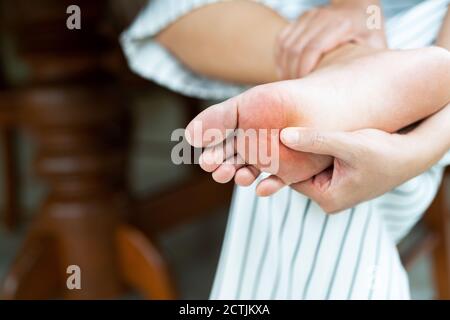 Femme en massant son douloureux pieds nus, les soins de santé et concept médical Banque D'Images