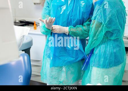 Médecin portant un gant de protection lorsqu'il se trouve au bureau près d'un assistant Banque D'Images