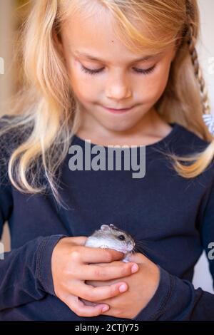 Petite fille mignonne jouant avec un hamster Banque D'Images