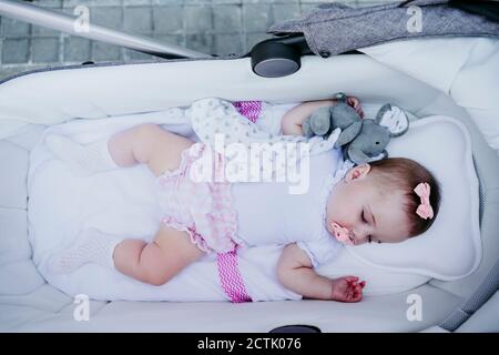 Bébé fille dormant dans la poussette Banque D'Images