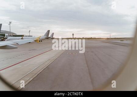 Piste au crépuscule vue de derrière la fenêtre de l'avion Banque D'Images