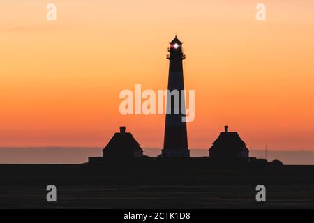 Allemagne, Schleswig-Holstein, Westerhever, Silhouette du phare de Westerheversand à l'aube moody Banque D'Images