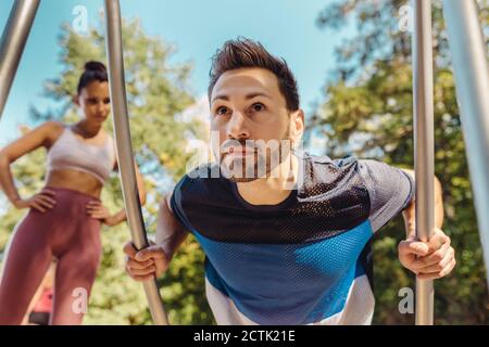 Femme regardant un homme faire des retouches sur un sentier de fitness Banque D'Images