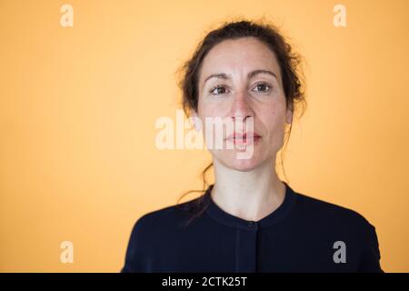 Gros plan de l'entrepreneur féminin contre le mur orange Banque D'Images