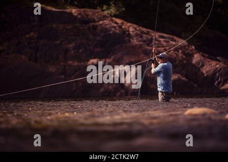 Pêche à la mouche coulée avec tige à deux mains dans la rivière Banque D'Images
