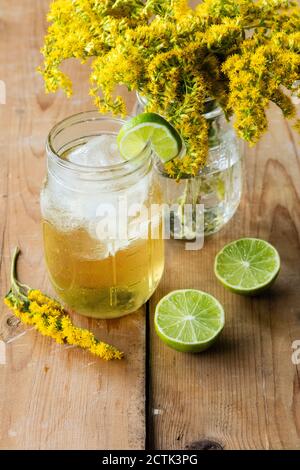 Pot de thé doré glacé avec des limes Banque D'Images