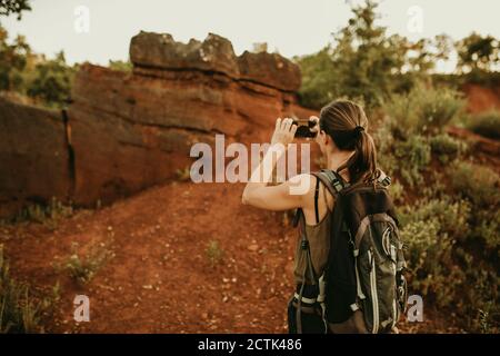 Une femme qui prend des photos sur un smartphone tout en étant debout forêt Banque D'Images