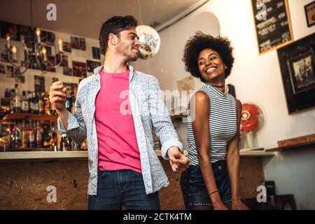Couple joyeux dansant à la discothèque Banque D'Images