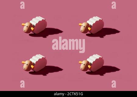 Motif de petites figurines de mouton blanc sur fond rouge Banque D'Images