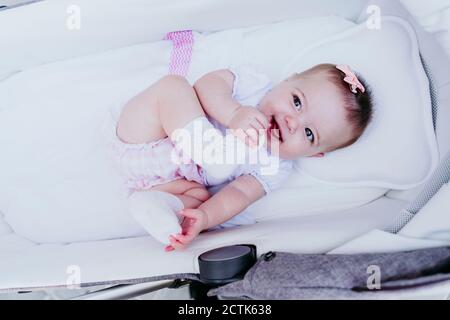 Bébé fille heureux couché dans la poussette Banque D'Images