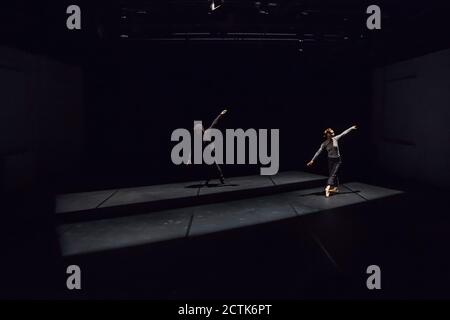 Danseuse masculine et féminine effectuant un ballet provisoire sur scène noire Banque D'Images