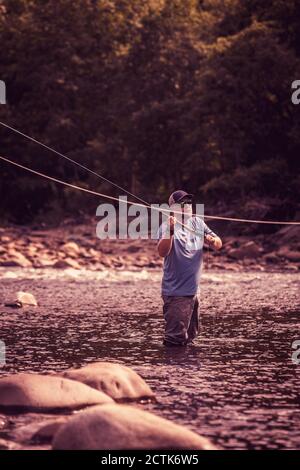 Pêche à la mouche coulée avec tige à deux mains dans la rivière Banque D'Images