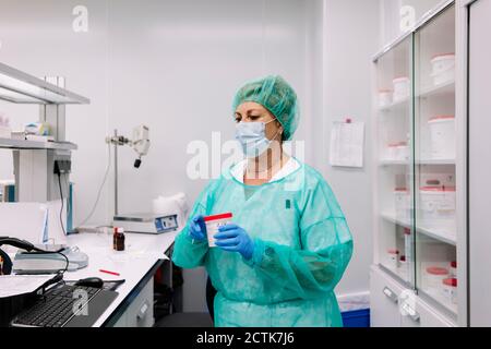 Une pharmacienne tient un flacon de médicament en laboratoire Banque D'Images