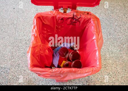 Seau à déchets médicaux. Déchets médicaux, le laboratoire a utilisé des boîtes et des gants de pétri et des flacons vides dans le seau à déchets de près. Banque D'Images